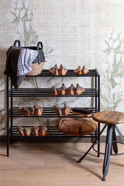 Black metal shoe rack with four shelves holding brown leather shoes and accessories