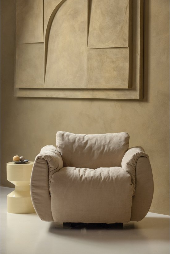 Cream upholstered armchair with rolled arms and cylindrical legs beside yellow metal side table