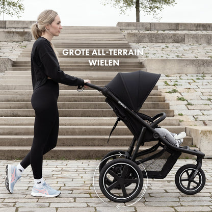 Deryan Bolt black jogging buggy with all-terrain wheels on stone steps