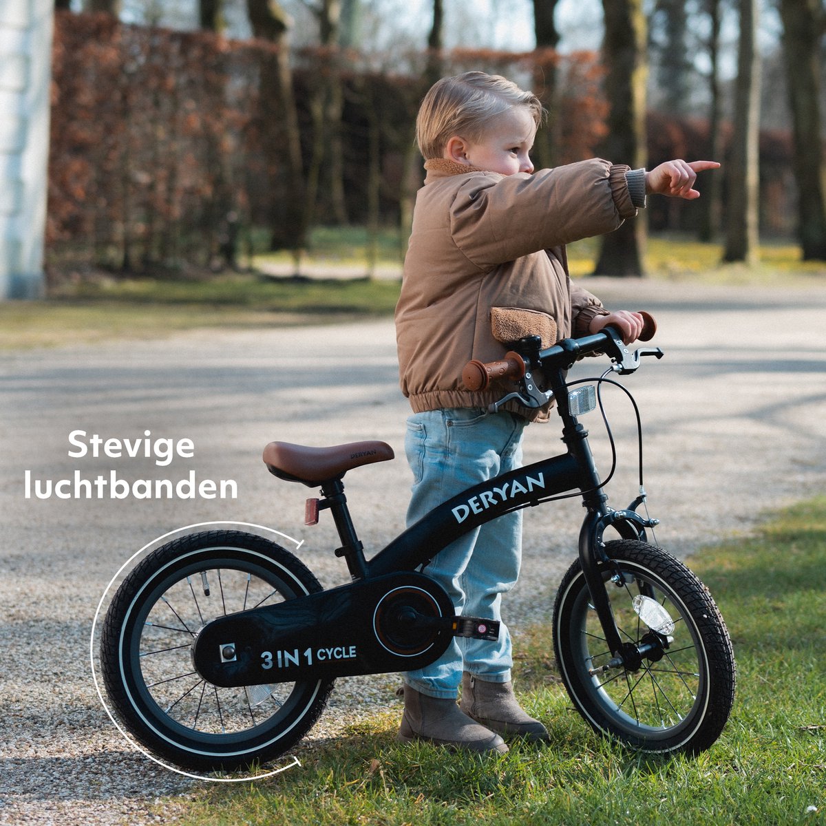 Toddler on black Deryan 12-inch training bike with brown seat outdoors